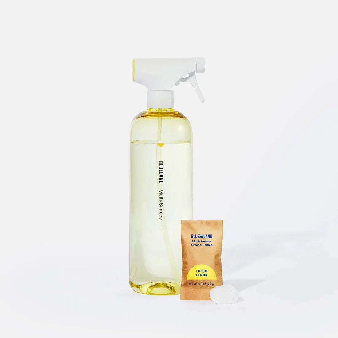 A Blueland multi-surface spray bottle beside its refill packet.