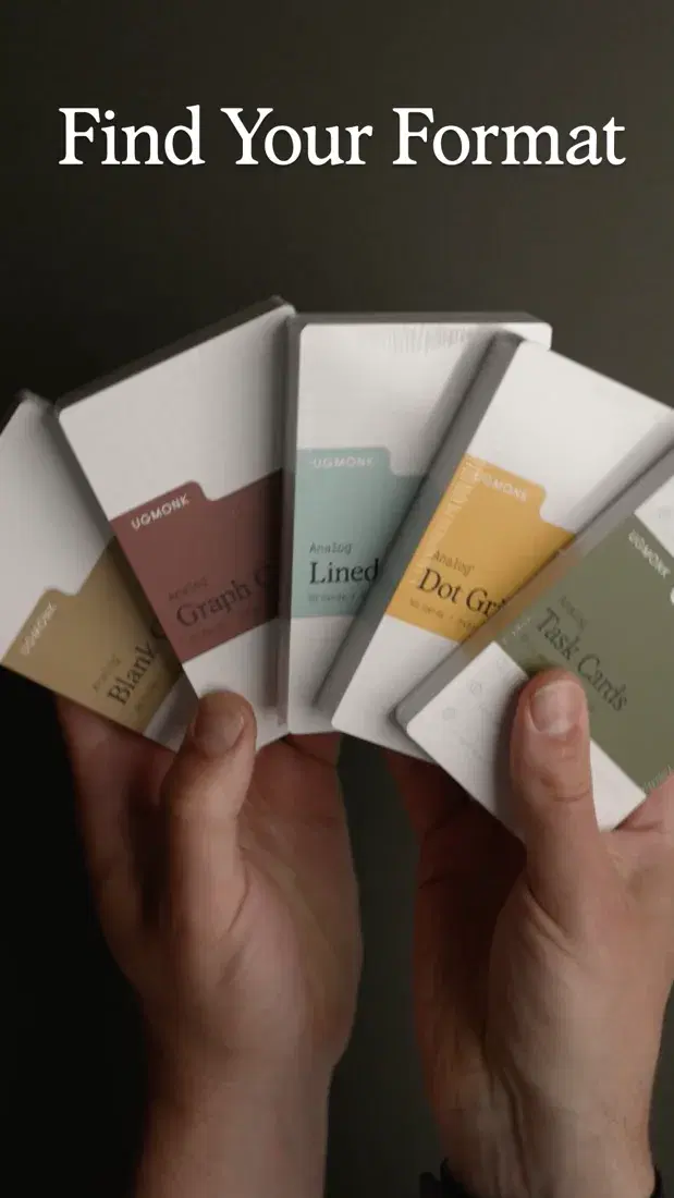 A hand holding several Ugmonk card formats for comparison.