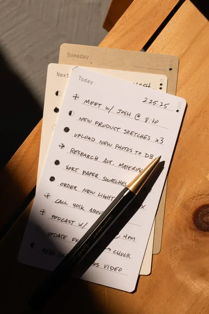 An Ugmonk task card and pencil on a wooden desk, showing the product in use.